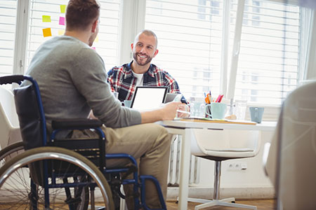 image of young man in wheelchair at work with colleague